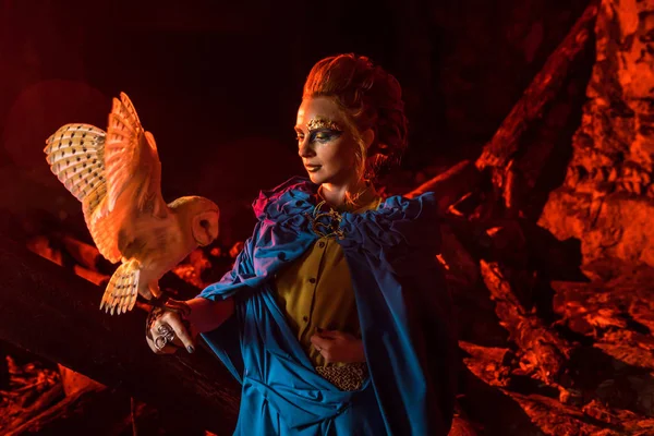 Güzel kırmızı saçlı cadı ile beyaz baykuş.