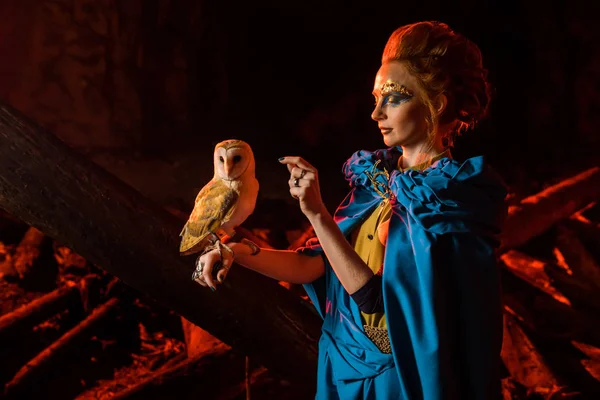 Beautiful red haired witch with the white owl. — Stock Photo, Image