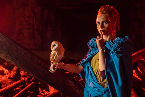 Güzel kırmızı saçlı cadı ile beyaz baykuş.