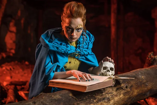 Hermosa bruja pelirroja con el libro de hechizos . — Foto de Stock