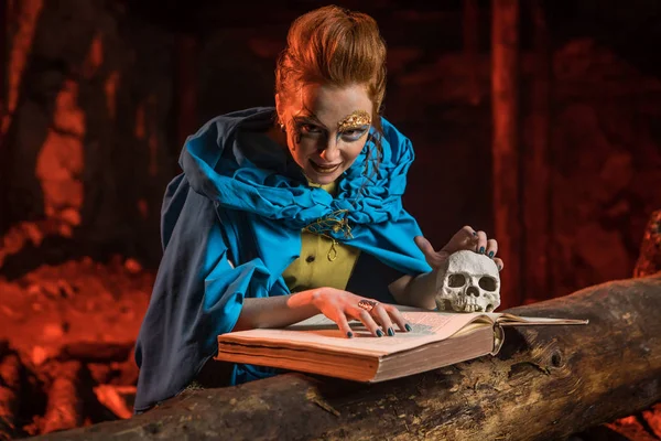 Beautiful red haired witch with the spellbook. — Stock Photo, Image