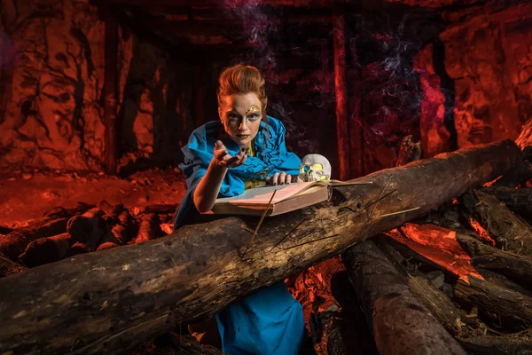 Hermosa bruja pelirroja con el libro de hechizos . — Foto de Stock