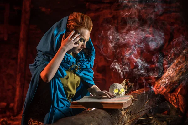 Gyönyörű vörös hajú boszorkány a spellbook. — Stock Fotó