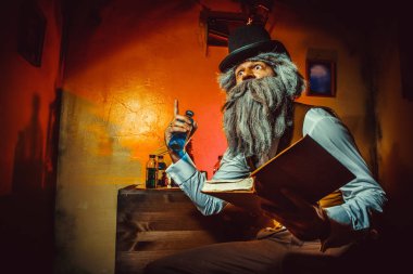 Sakallı adam bir elinde kitap ve başka bir şişe