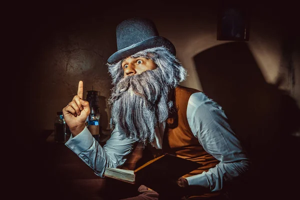 Бородатый мужчина в черной шляпе и жилете с книгой . — стоковое фото