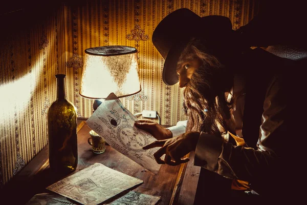 Bearded man reads a mysterious letter in the dark room — Stock Photo, Image