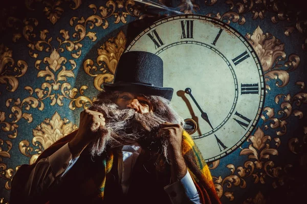Homme caucasien senior debout près de l'horloge murale dans la chambre noire . — Photo