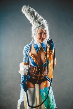 Güzel kadın eğitmen seksi sirk elbiseli kamçı ile