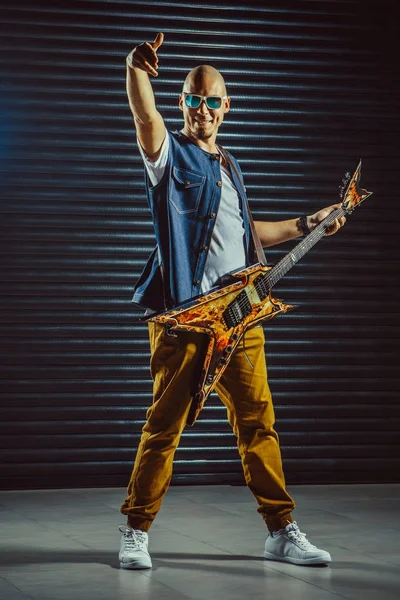 Сміливий гітарист робить жест рок-н-ролу під час крику та гри — стокове фото
