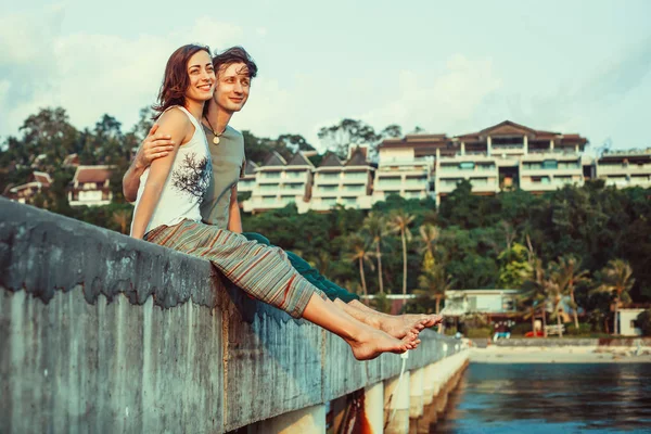 Pareja joven se relaja en el piercing viendo el mar . —  Fotos de Stock