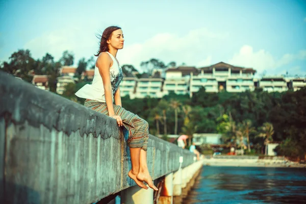 Giovane donna è rilassante sul piercing guardando il mare . — Foto Stock