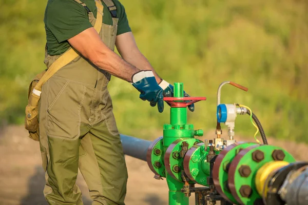 El trabajador petrolero está girando la válvula en el oleoducto . — Foto de Stock