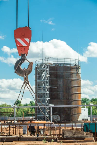 Bouw van een olietank, olie storting op de achtergrond. — Stockfoto