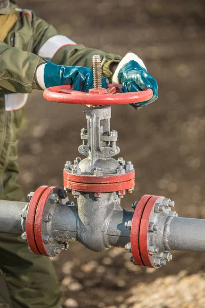 Працівник нафти повертає клапан на нафтопровід . — стокове фото