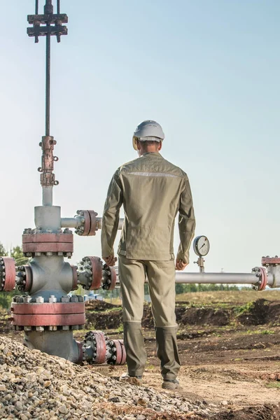Travailleur du pétrole vérifie la pompe à huile . — Photo