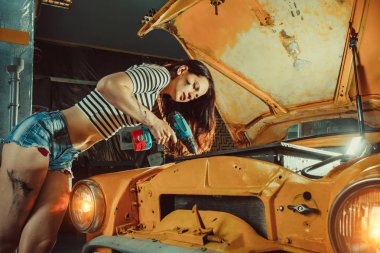 Genç seksi kadın makinist onarım garaj motoru tamir ediyor