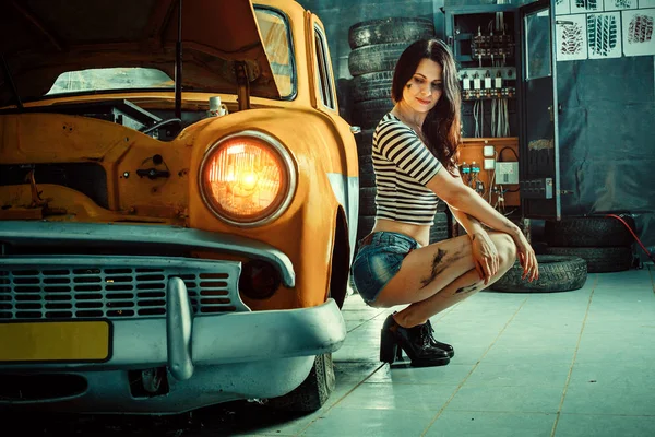 Mechanik Kobieta w seksowny spodenki, w pobliżu zabytkowych samochodów — Zdjęcie stockowe