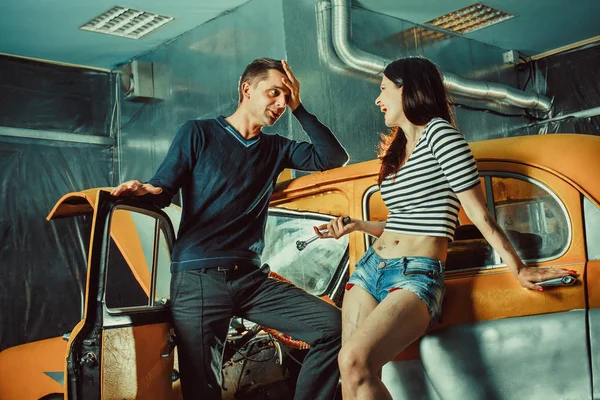 Woman mechanic in sexy shorts is listening to the customer — Stock Fotó