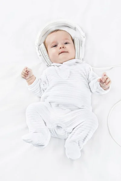 Schattige baby in hoofdtelefoons op witte achtergrond — Stockfoto