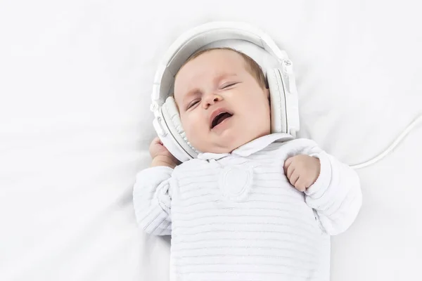 Schattige baby in hoofdtelefoons op witte achtergrond — Stockfoto