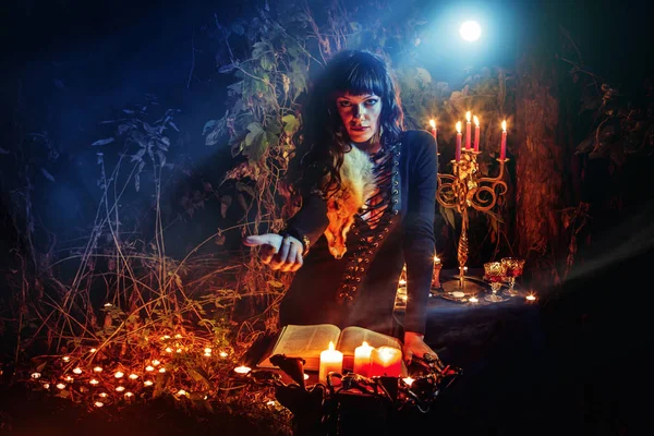 Hermosa bruja con el libro vintage de magia te invita al bosque . — Foto de Stock