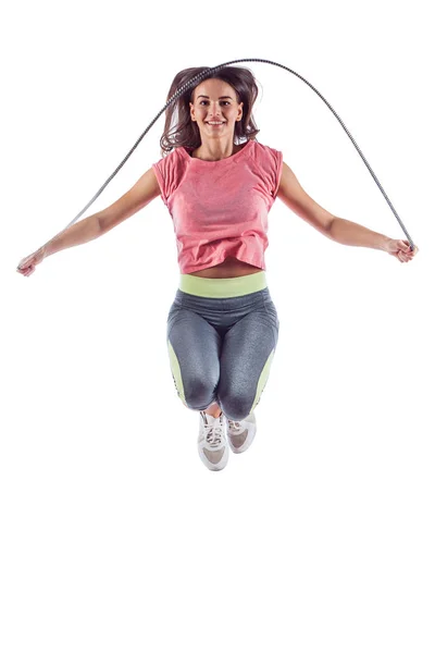 Portrait of muscular young woman exercising with jumping rope. — Stock Photo, Image