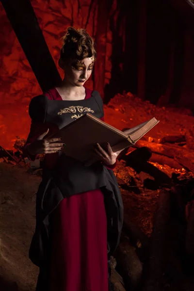 Bruxa jovem bonita com o livro de feitiços . — Fotografia de Stock