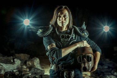 Zindan arka planında paslı miğferi olan kıyamet sonrası kadın. Nükleer kıyamet sonrası zamanı. Evet. Kıyamet sonrası yaşam