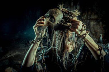 Zindan arka planında paslı kafatası maskeli kıyamet sonrası kadın. Nükleer kıyamet sonrası zamanı. Evet. Kıyamet sonrası yaşam