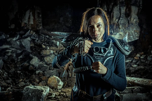 Post-apocalyptic woman with the chain and sword in hands on the dungeon background. Nuclear post-apocalypse time. Life after doomsday — Stock Photo, Image