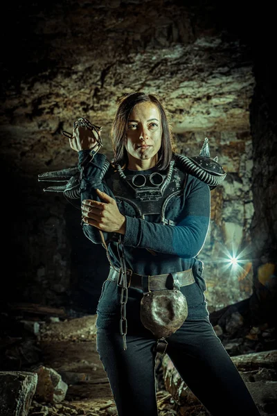 Postapokalyptische Frau mit einer Kette in den Händen auf dem Dungeon-Hintergrund. Zeit nach der Apokalypse. Leben nach dem Weltuntergang — Stockfoto