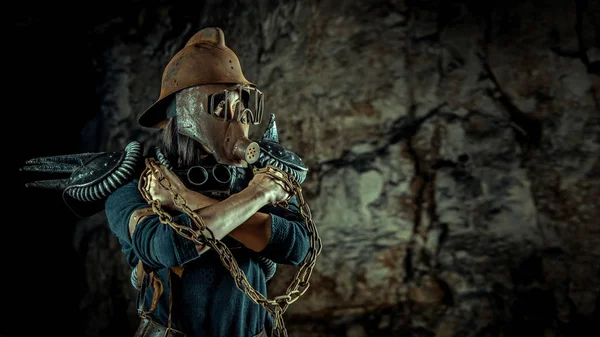 Post-apocalyptic woman in the rusty helmet with a chain in hands on the dungeon background. Nuclear post-apocalypse time. Life after doomsday — Stock Photo, Image