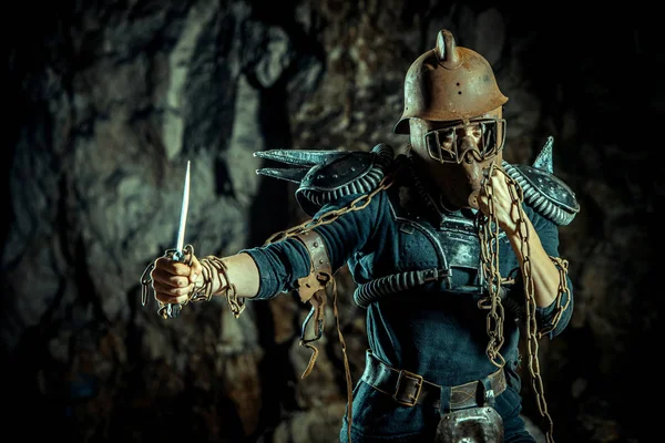 Post-apocalyptic woman in the rusty helmet with a chain and knife in hands on the dungeon background. Nuclear post-apocalypse time. Life after doomsday — Stock Photo, Image