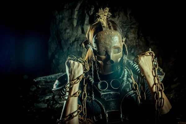 Mujer post-apocalíptica con la máscara de cráneo oxidado en el fondo de la mazmorra. Tiempo de post-apocalipsis nuclear. La vida después del juicio final —  Fotos de Stock