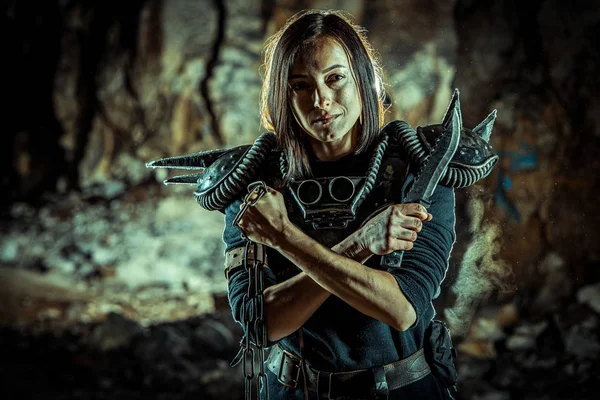 Post-apocalyptic woman with the chain and sword in hands on the dungeon background. Nuclear post-apocalypse time. Life after doomsday — Stock Photo, Image