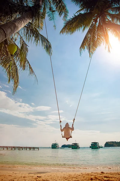 Linda jovem está balançando em um balanço que pendura em uma árvore e desfrutando do belo clima de verão na ilha Phu Quoc, Vietnã . — Fotografia de Stock