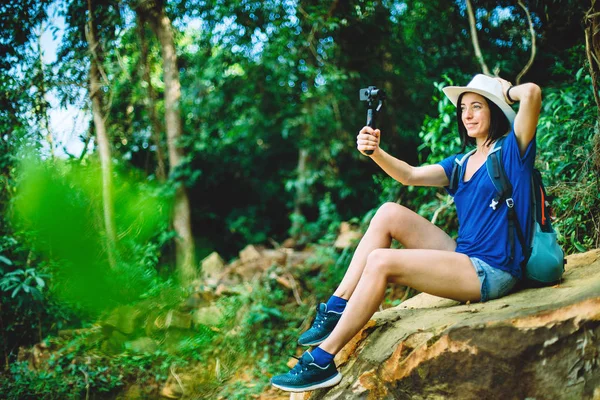 Young traveler with action camera in the jungle. Discovery concept. — Stock Photo, Image