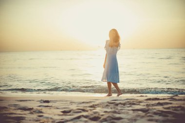 Kumsalda yürüyen genç bir kadın. Phu Quoc Adası, Vietnam