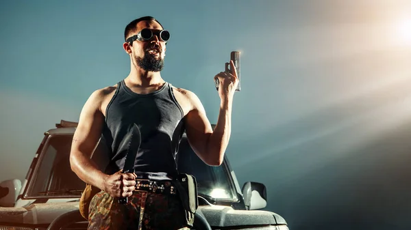 Portrait of a serious gangster man with gun in front of his car — 스톡 사진