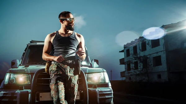 Portrait of a serious gangster man with gun in front of his car — Stock Photo, Image