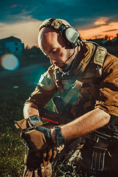 Американский солдат с винтовкой М4 отдыхает. Закат на заднем плане . — стоковое фото