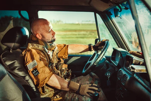 Soldado careca de uniforme está dirigindo veículo militar . — Fotografia de Stock