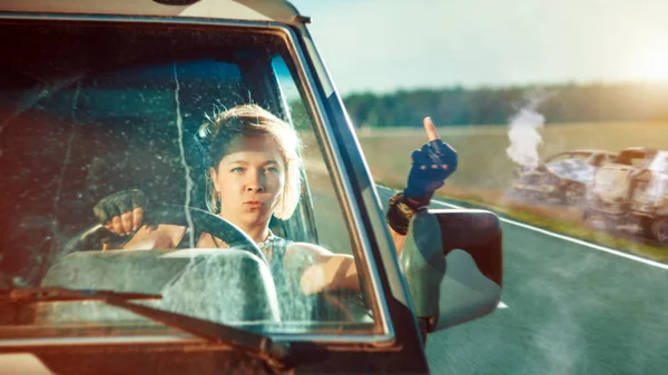 制服を着たブロンドの兵士の女性が軍用車両を運転している. — ストック写真