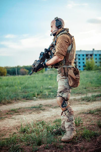 Soldado americano com a espingarda M4 no fundo da cidade arruinada — Fotografia de Stock