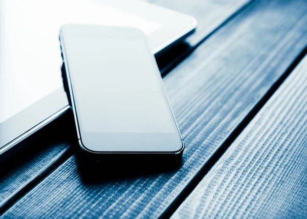 Smartphone and tablet on wooden desk — Stock Photo, Image