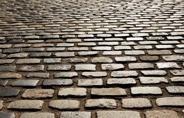 Sunlight on cobblestone road — Stock Photo, Image