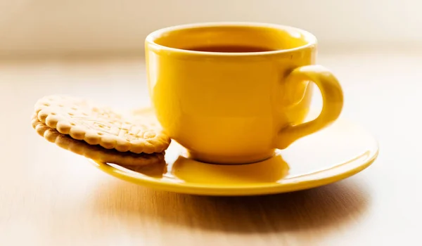 Té en taza amarilla y galleta —  Fotos de Stock