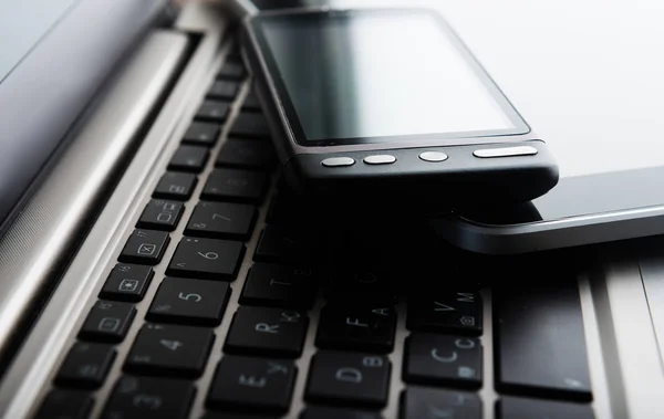Smartphone y tablet colocados en el teclado — Foto de Stock