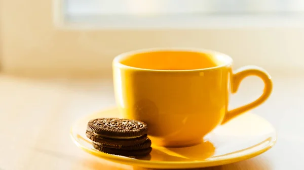 Té en taza amarilla y galleta —  Fotos de Stock
