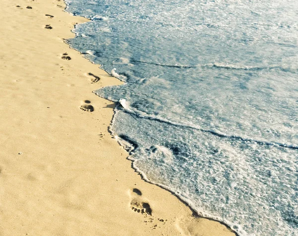 Empreintes de pas sur sable avec mousse — Photo